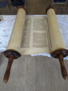 Torah scroll partially unrolled and laid flat on a table